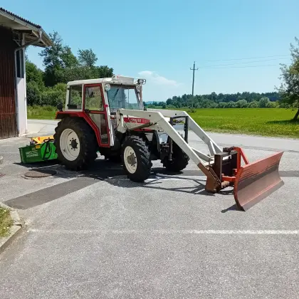 Steyr 8055A mit Kippmulde, Frontlader, Schneeschild